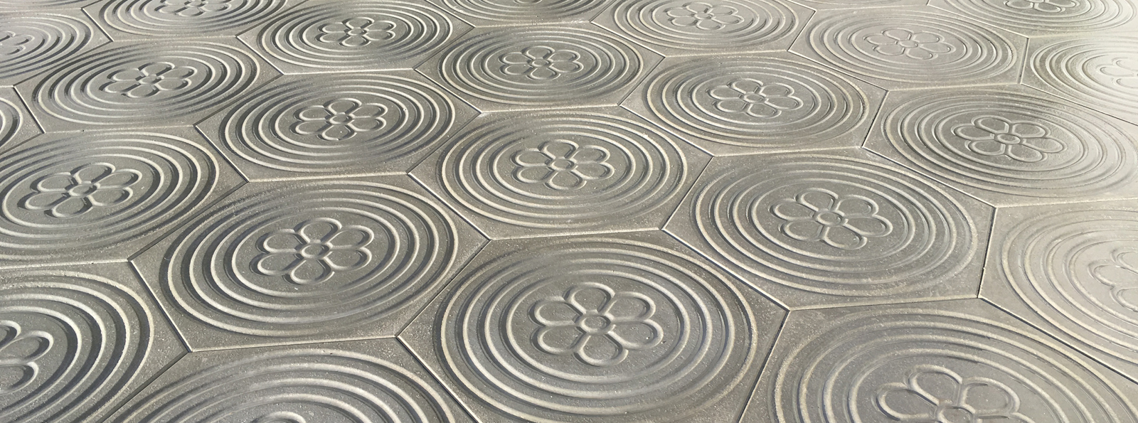 Trottoirplatten mit Kreisen und Blumen als Msuter